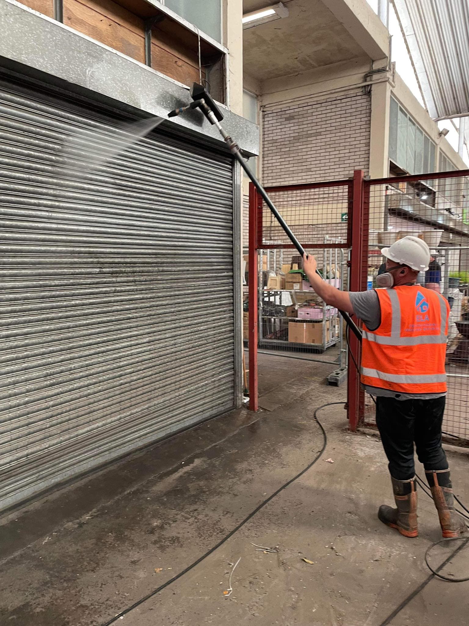 Shutters being cleaned with pressure washer